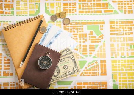 Composition with passport, money and immigration bureau cards on city map. Travel planning concept Stock Photo