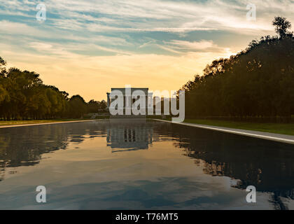 Setting sun behind the Lincoln memorial in Washington DC reflecting into the surface in the reflection pool Stock Photo