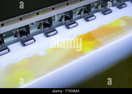 Close up inkjet printer working on yellow vinyl banner Stock Photo