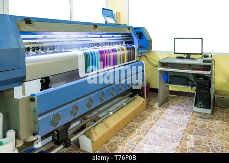 Large inkjet printer working multicolor cmyk on vinyl banner with computer control in printing plant Stock Photo