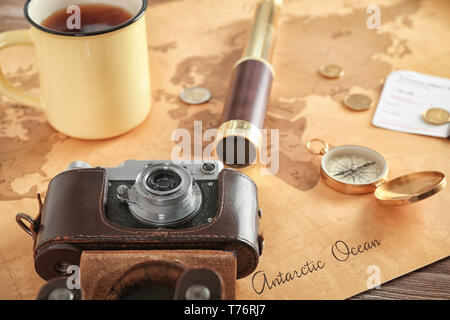 Composition with photo camera and mug of tea on vintage map . Travel planning concept Stock Photo