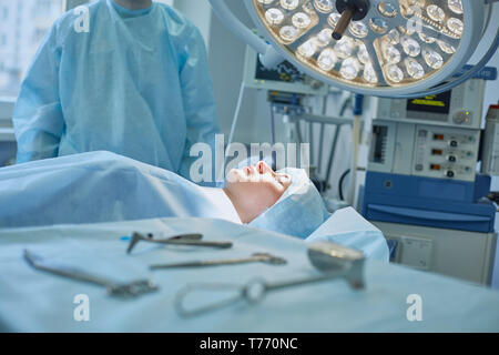 Several doctors surrounding patient on operation table during their work. Team surgeons at work in operating room. Stock Photo
