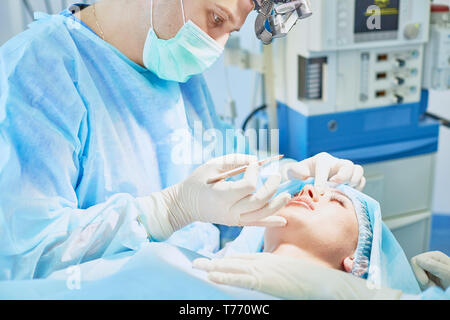 Several doctors surrounding patient on operation table during their work. Team surgeons at work in operating room. Stock Photo