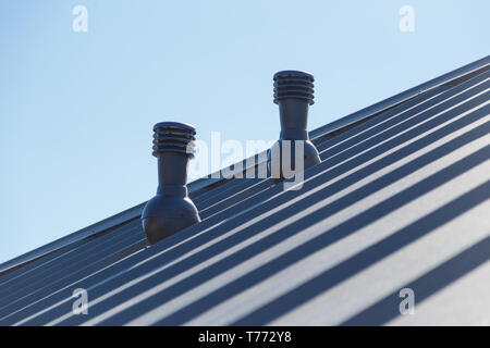 Exhaust pipe on the private house roof. Stock Photo