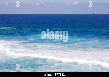 Beautiful image of turquoise blue sea and wash created by waves looking out over ocean in Australia Stock Photo