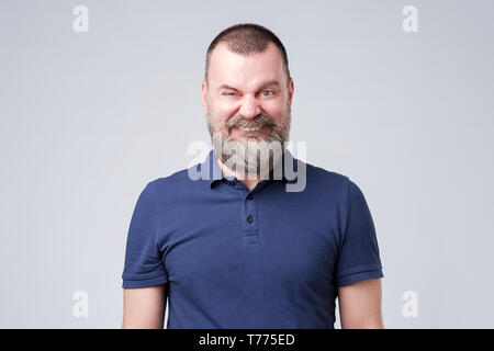 Mature male making a funny smiling grimace. Studio shot Stock Photo