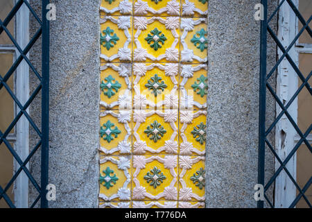 yellow floral decorative tiles on the wall of a building in Porto Portugal. Stock Photo