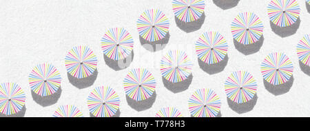 Colorful umbrellas on white sand - top view Stock Photo