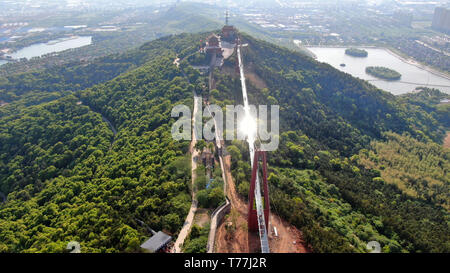 Wuxi. 4th May, 2019. Aerial photo taken on May 4, 2019 shows tourists walking on a glass bridge at the Huaxi World Adventure Park in Huaxi Village of Jiangyin City, east China's Jiangsu Province. The 518-meter-long glass bridge hangs more than 100 meters above ground level at the park. It is made of panes of 35-mm-thick glass. Each glass can hold a maximum weight of 4.7 tonnes. Around 2,600 people can cross the bridge at a time. Credit: Xu Congjun/Xinhua/Alamy Live News Stock Photo