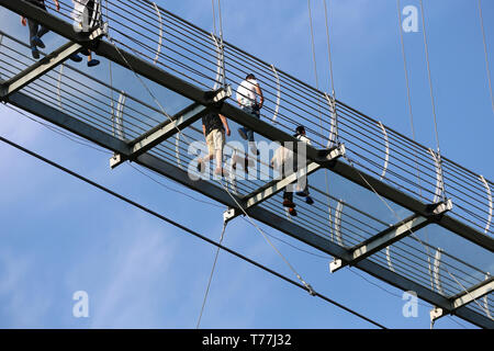 Wuxi, China's Jiangsu Province. 4th May, 2019. Tourists walk on a glass bridge at the Huaxi World Adventure Park in Huaxi Village of Jiangyin City, east China's Jiangsu Province, May 4, 2019. The 518-meter-long glass bridge hangs more than 100 meters above ground level at the park. It is made of panes of 35-mm-thick glass. Each glass can hold a maximum weight of 4.7 tonnes. Around 2,600 people can cross the bridge at a time. Credit: Xu Congjun/Xinhua/Alamy Live News Stock Photo