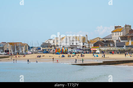 Lyme Regis, Dorset, UK. 5th May 2019. UK Weather: Visitors enjoy warm sunny spells with a light cooling breeze on the beach at Lyme Regis. Cooler conditions are forecast over the May Bank Holiday weekend. Credit: Celia McMahon/Alamy Live News. Stock Photo