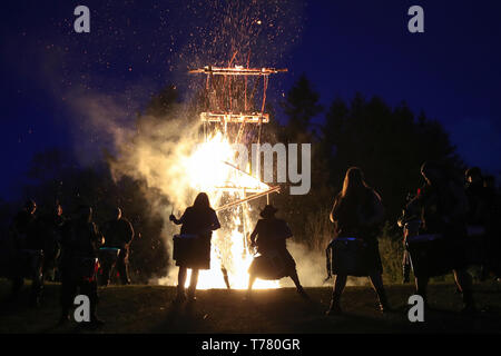 Members of the Pentacle Drummers perform in front of the burning wickerman during the Beltain Festival, an ancient Celtic celebration to mark the beginning of summer, at Butser Ancient Farm, Waterlooville, Hampshire. Stock Photo
