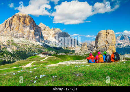 Sporty healthy active group of hikers with colorful backpacks and mountain equipment sitting and enjoying panoramic view, Dolomites, Italy, Europe Stock Photo