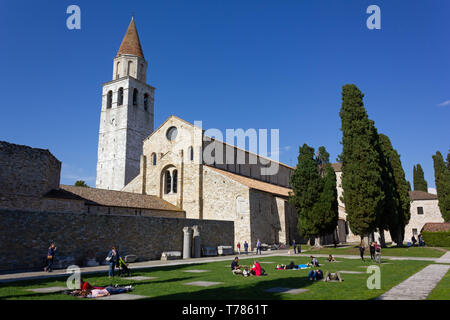 AQUILEIA, Italy - May 1, 2019: The Basilica and its park full of people in a springtime sunny afternoon Stock Photo