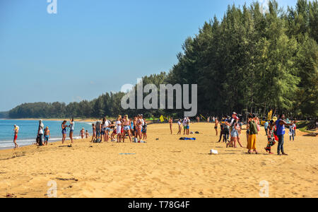 Phuket, Thailand - Apr 4, 2019. People fall on the sand beach by the strong wind from the airplane that taking off from Phuket Airport (HKT). Stock Photo