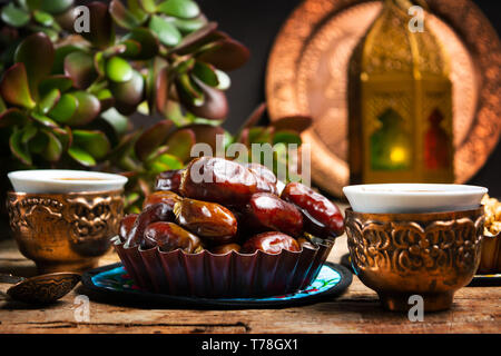 Dates served with coffee in Arabic style arrangement on a table Stock Photo