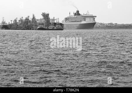 Black And White Photo Of The Cunard Line Flagship, RMS QUEEN MARY 2, Steaming Past The Fawley Oil Refinery As She Departs Southampton For New York Stock Photo