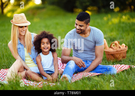 Picture of lovely couple with their daughter having picnic Stock Photo