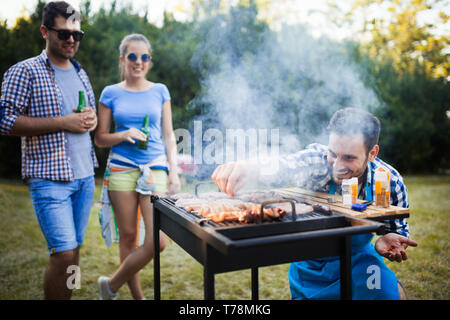 Happy friends enjoying barbecue party in forest Stock Photo