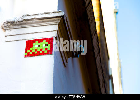 Mosaic on the wall of a building depicting a space invader by street artist Invader Stock Photo