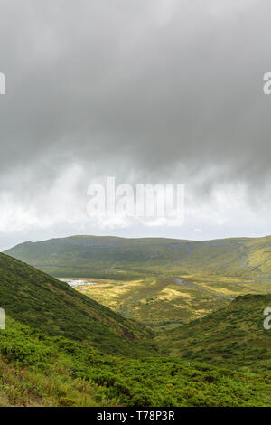 Portrait view of a hill leading down to Caldeira Branca on Flores Island in Portugal. Stock Photo