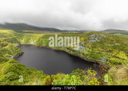 The black waters of Caldeira Comprida on the island of Flores in the Azores. Stock Photo