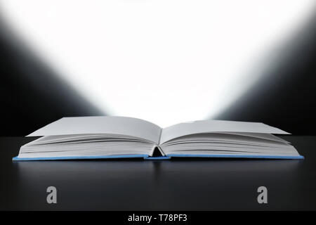 Open book with glowing on dark background Stock Photo