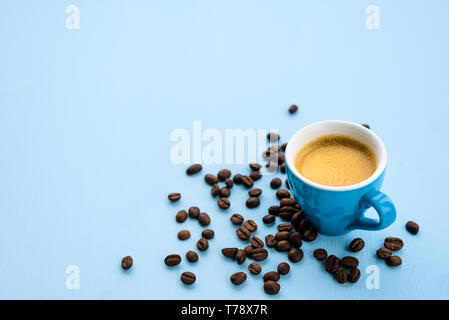 Blue espresso cup with coffee on blue pastel background with beans around Stock Photo