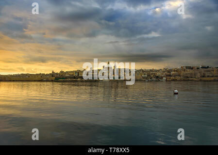 Classic postcard view to Basilica of Our Lady of Mount Carmel and St Paul's Pro-Cathedral. Valletta, Malta. Sky with moody clouds, sunrise Stock Photo