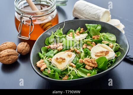 Salad of lamb's lettuce, goat cheese, walnuts, closeup, hard focus Stock Photo
