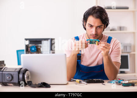 Young male contractor repairing computer Stock Photo