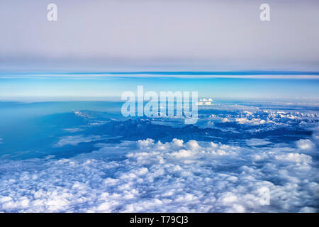 Aerial view of monsoon clouds over lesser Himalayas in India. The snow covered peaks of Shivalik/Dhauladhar mountain range can be seen on top right. Stock Photo