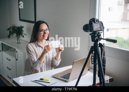 Girl video blogger or online foreign language teacher writes a training video for their subscribers to upload to social networks. Stock Photo
