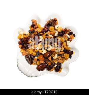 Mix of nuts and berries: raisins, hazelnut, cashews, almonds, cranberries, dried dates and apricots. Plate of dried fruits on white, isolated on white Stock Photo