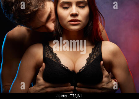 passionate man hugging his girlfriend breast and kissing her. close up  photo Stock Photo