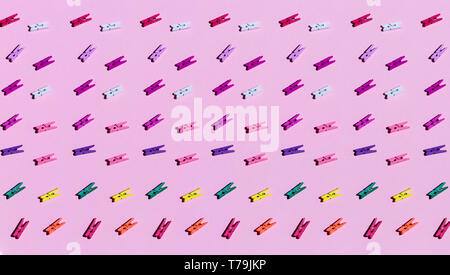 A lot of colorful wooden clothespins isolated on a pink background. top view.entertainment, creative games for children Stock Photo