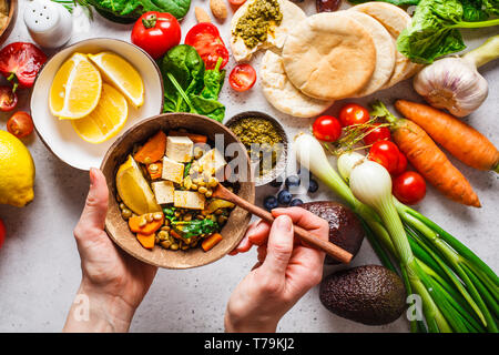 Healthy vegetarian food background. Vegetables, hummus, pesto and lentil curry with tofu. Stock Photo