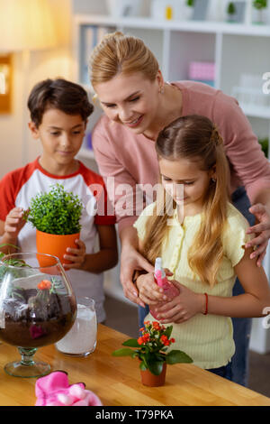 School boy and girl watering plants in garden Stock Photo - Alamy