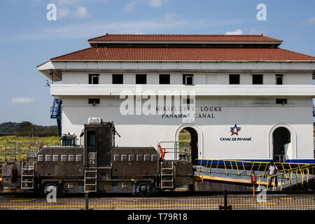 Miraflores Locks, Panama Canal, Panama - March 08, 2016: White building with the Canal de Panama logo and a mule, electric locomotive, in front of it Stock Photo