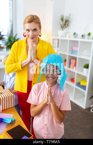 Interesting art lesson. Cheerful boy and his beautiful teacher having fun after interesting art lesson Stock Photo