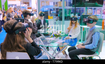 Group of teenagers using virtual reality headset at technology show Stock Photo