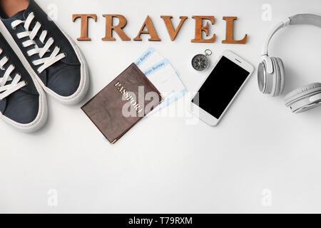Composition with passport, immigration bureau cards, smartphone and word 'Travel' on white background Stock Photo