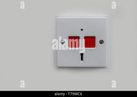 White plastic panic panel with two red square push buttons and a key hole to reset.  Push here in an emergency. Stock Photo