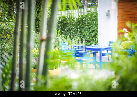 Blue chairs and table set in the garden Stock Photo