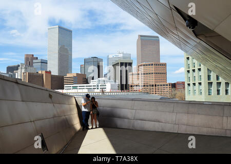 Denver, Colorado - May 4, 2019: A couple taking pictures on the deck with a view on Denver downtown cityscape Stock Photo