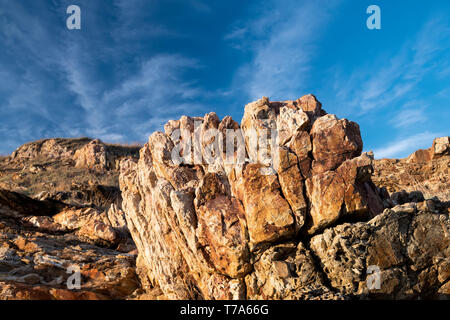 Texture of strange boulder rocks dark nook and warm color with sun lighting. Stock Photo