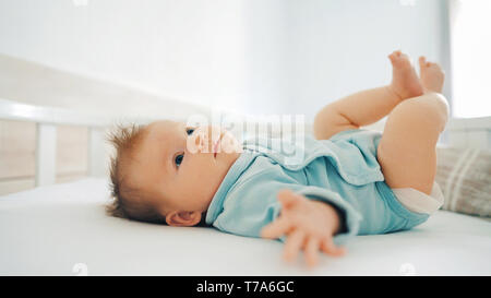 Infant girl lying on bed at home adorable 2 month old baby kid Stock Photo