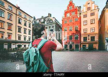 Man sightseeing Stockholm city Stortorget landmarks traveling lifestyle taking photo by smartphone Europe trip summer vacations Stock Photo