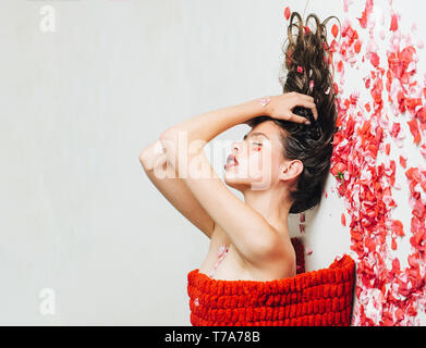 Young woman lie in rose petals Stock Photo