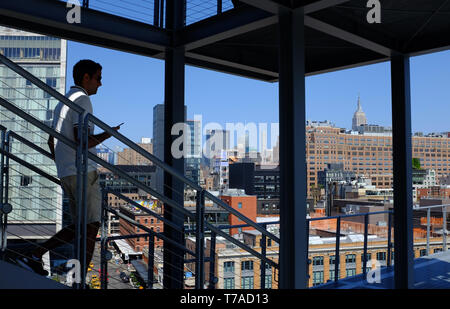 Visitors on staircase of outdoor terrace of Whitney Museum of America Art with the Standard Hotel in Meatpacking district in background.New York City. Stock Photo